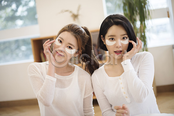 20대 두명 성인 성인여자만 여자 한국인 JPG 앞모습 포토 거실 눈가 만지기 미소(표정) 뷰티 상반신 실내 앉기 우먼라이프 응시 주름 친구 팩 피부관리
