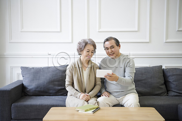 60대 남자 노년 노인만 두명 여자 한국인 JPG 앞모습 포토 가족 거실 노부부 독서 들기 상반신 소파 실내 앉기 웃음 전자책 태블릿 평생교육 할머니 할아버지