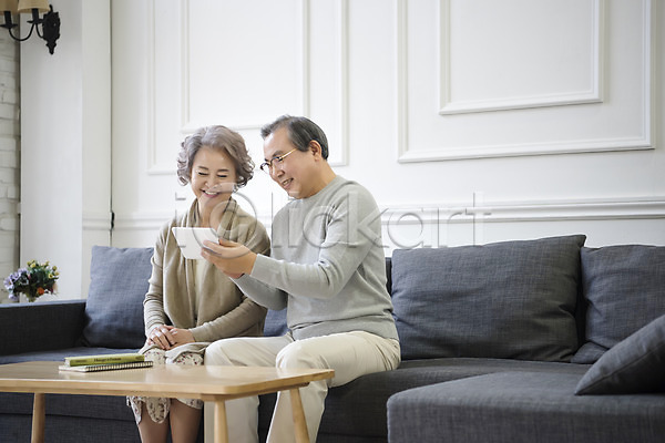 60대 남자 노년 노인만 두명 여자 한국인 JPG 앞모습 포토 가족 거실 노부부 독서 상반신 소파 실내 앉기 웃음 전자책 태블릿 평생교육 할머니 할아버지