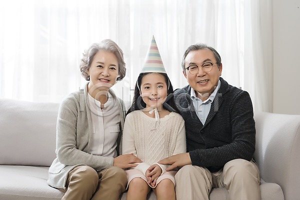 10대 60대 남자 노년 세명 어린이 여자 한국인 JPG 앞모습 포토 가족 거실 고깔(모자) 노부부 상반신 생일파티 소파 손녀 실내 앉기 웃음 할머니 할아버지