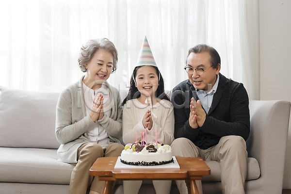즐거움 행복 10대 60대 남자 노년 세명 어린이 여자 한국인 JPG 앞모습 포토 가족 거실 고깔(모자) 노부부 박수 상반신 생일케이크 생일파티 소파 손녀 실내 앉기 웃음 할머니 할아버지
