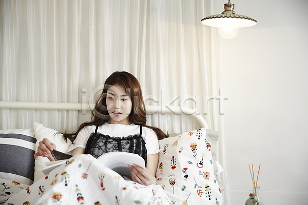 20대 성인 성인여자한명만 여자 한국인 한명 JPG 앞모습 포토 기댐 독서 베개 상반신 실내 앉기 웃음 응시 이불 조명 책 침대