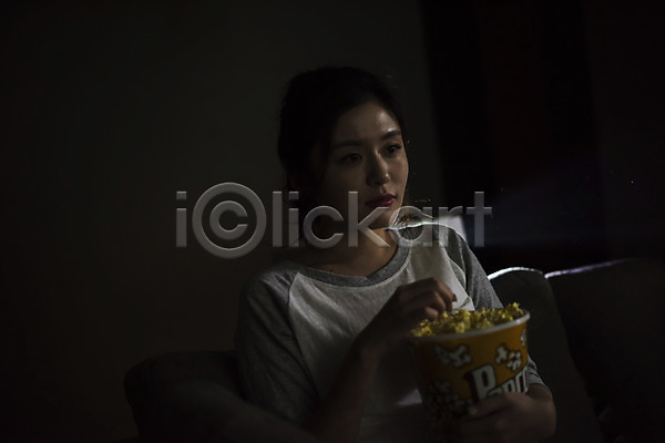 20대 성인 성인여자한명만 여자 한국인 한명 JPG 앞모습 포토 관람 먹기 상반신 실내 앉기 어둠 영화 영화관람 우먼라이프 응시 팝콘 프로젝터