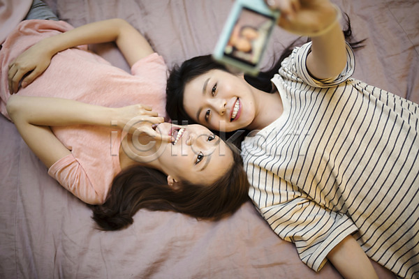 우정 20대 두명 성인 성인여자만 여자 한국인 JPG 앞모습 포토 하이앵글 눕기 들기 룸메이트 상반신 셀프카메라 실내 우먼라이프 웃음 친구 침대 카메라 포즈