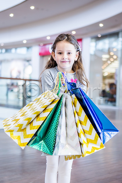 서양인 소녀(어린이) 소녀만 어린이 여자 한명 JPG 아웃포커스 앞모습 포토 들기 미소(표정) 상반신 상점 서기 쇼핑 쇼핑몰 쇼핑백 실내