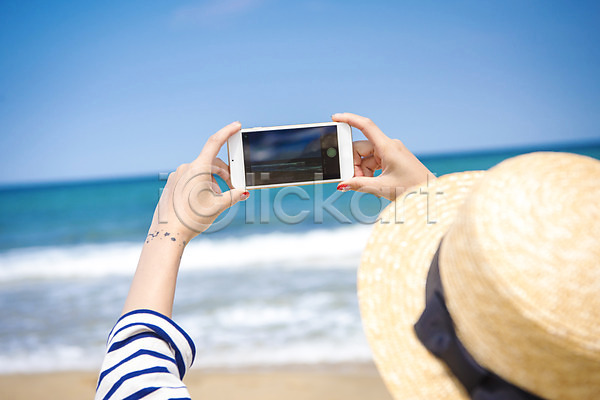 휴식 20대 성인 성인여자한명만 여자 한명 JPG 뒷모습 아웃포커스 포토 들기 모자(잡화) 바다 사진촬영 상반신 서기 스마트폰 야외 여름(계절) 여름풍경 주간 풍경(경치) 휴가
