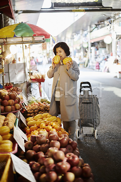 50대 여자 중년 중년여자한명만 한국인 한명 JPG 아웃포커스 앞모습 포토 과일 냄새 들기 미소(표정) 상반신 서기 시장 야외 응시 장바구니 장보기 주간 중년라이프 참외
