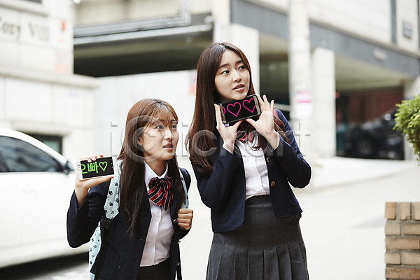 우정 10대 두명 십대여자만 여자 청소년 한국인 JPG 아웃포커스 앞모습 포토 건물 교복 기다림 들기 백팩 상반신 서기 스마트폰 야외 여학생 응시 자동차 주간 친구 팬(애호가) 학생