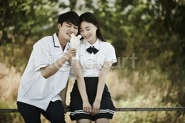 20대 남자 두명 성인 여자 한국인 JPG 아웃포커스 앞모습 포토 공원 교복 나무 난간 데이트 들기 미소(표정) 상반신 손풍기 앉기 야외 주간 커플 학생