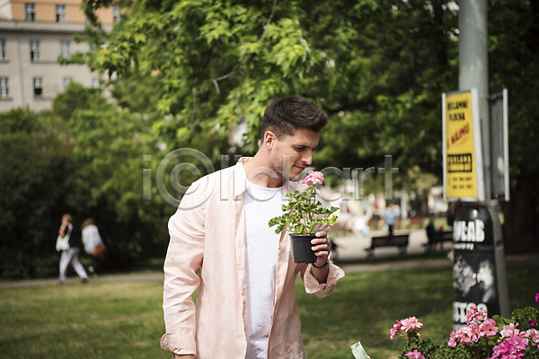 20대 남자 서양인 성인 성인남자한명만 한명 JPG 아웃포커스 앞모습 포토 꽃 나무 냄새 들기 미소(표정) 상반신 서기 야외 유럽 잔디 주간 체코 프라하 화분