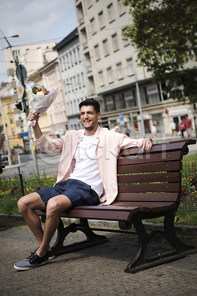 20대 남자 서양인 성인 성인남자한명만 한명 JPG 아웃포커스 앞모습 포토 꽃다발 들기 미소(표정) 벤치 앉기 야외 유럽 전신 주간 체코 프라하