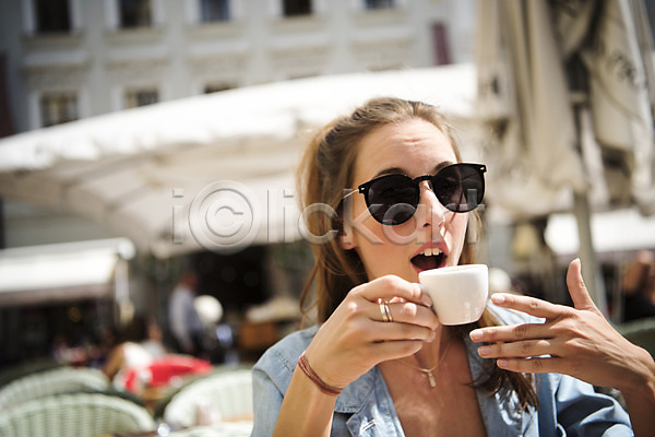 20대 서양인 성인 성인여자한명만 여자 한명 JPG 아웃포커스 앞모습 포토 놀람 미소(표정) 상반신 앉기 야외 유럽 응시 주간 체코 카페 커피 커피잔 프라하
