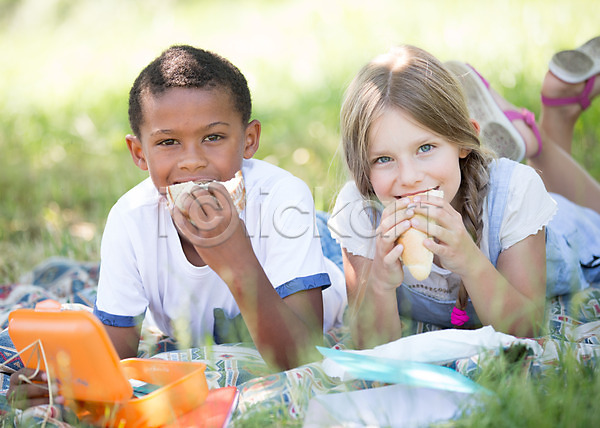 남자 두명 서양인 소녀(어린이) 소년 어린이 어린이만 여자 흑인 JPG 아웃포커스 앞모습 포토 눕기 먹기 샌드위치 소풍 야외 어린이라이프 엎드리기 주간 친구