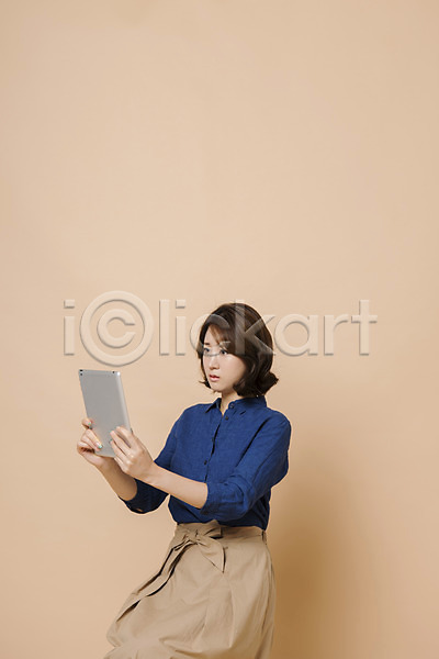20대 성인 성인여자한명만 여자 여자한명만 한국인 한명 JPG 옆모습 포토 들기 모션 베이지색배경 상반신 스튜디오촬영 실내 앉기 컬러 태블릿 표정