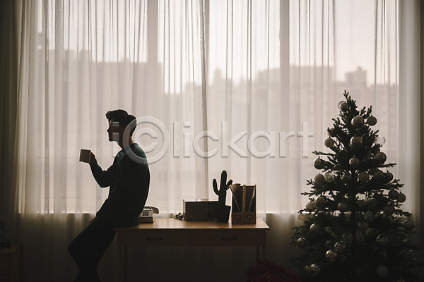 휴식 20대 남자 성인 성인남자한명만 한국인 한명 JPG 실루엣 옆모습 포토 거실 들기 상반신 실내 앉기 책상 커튼 크리스마스 크리스마스트리