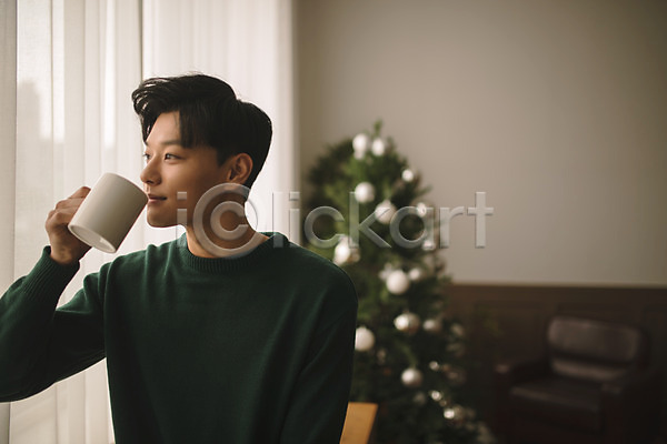 휴식 20대 남자 성인 성인남자한명만 한국인 한명 JPG 아웃포커스 앞모습 포토 거실 들기 상반신 실내 앉기 응시 커피잔 크리스마스 크리스마스트리