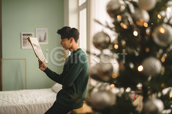 휴식 20대 남자 성인 성인남자한명만 한국인 한명 JPG 아웃포커스 옆모습 포토 들기 상반신 신문 실내 앉기 응시 침대 크리스마스 크리스마스트리