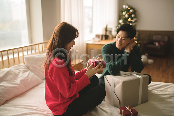 다정 20대 30대 남자 두명 성인 성인만 여자 한국인 JPG 아웃포커스 앞모습 옆모습 포토 들기 미소(표정) 상반신 선물 선물상자 실내 앉기 응시 침대 커플 크리스마스 크리스마스트리
