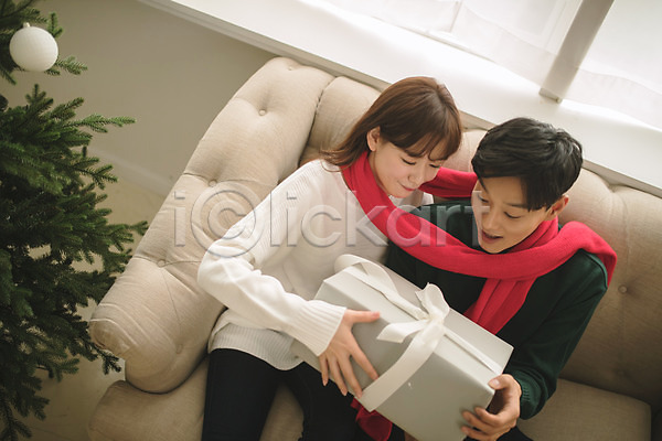 다정 20대 30대 남자 두명 성인 성인만 여자 한국인 JPG 앞모습 포토 거실 들기 목도리 미소(표정) 상반신 선물 소파 실내 앉기 응시 커플 크리스마스 크리스마스트리