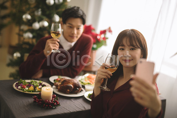 다정 20대 30대 남자 두명 성인 성인만 여자 한국인 JPG 아웃포커스 앞모습 포토 들기 미소(표정) 상반신 셀프카메라 스마트폰 식탁 실내 앉기 와인 와인잔 음식 커플 크리스마스 크리스마스트리
