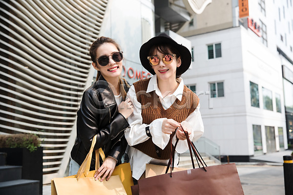 우정 20대 30대 두명 성인 성인여자만 여자 한국인 JPG 앞모습 포토 거리 들기 모자(잡화) 상반신 서기 쇼핑 쇼핑백 싱글라이프 야외 우먼라이프 주간 친구