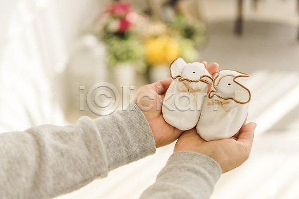 성인 성인여자한명만 신체부위 여자 한명 JPG 아웃포커스 포토 들기 손 실내 아기신발 아기용품