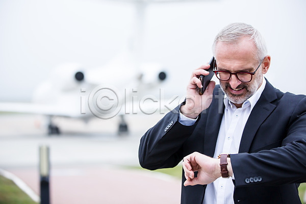 출장 남자 노년 노인남자한명만 서양인 한명 JPG 아웃포커스 앞모습 포토 공항 비즈니스맨 비행기 상반신 손목시계 스마트폰 시간 야외 주간 통화