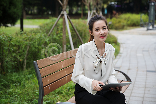 20대 성인 성인여자한명만 여자 한국인 한명 JPG 앞모습 포토 공원 들기 미소(표정) 벤치 비즈니스우먼 상반신 싱글라이프 앉기 야외 우먼라이프 주간 태블릿