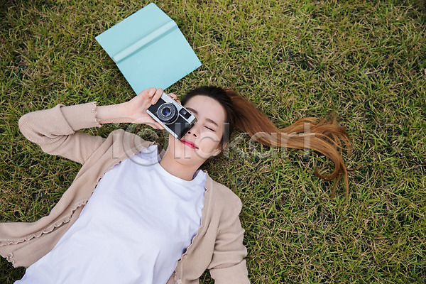 휴식 20대 성인 성인여자한명만 여자 한국인 한명 JPG 앞모습 포토 공원 눕기 사진촬영 상반신 싱글라이프 야외 우먼라이프 잔디 주간 책 카메라
