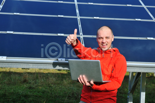 남자 성인 성인남자한명만 한명 JPG 앞모습 포토 해외이미지 노트북 들기 따봉 미소(표정) 상반신 야외 주간 집열판 태양에너지 해외202004
