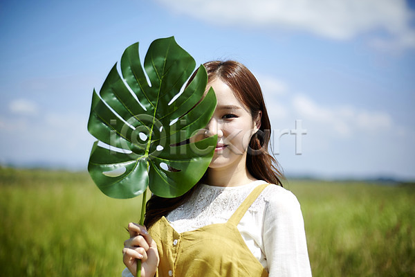 20대 사람 성인여자한명만 여자 한국인 한명 JPG 앞모습 포토 갈대습지 나뭇잎 들기 맑음 미소(표정) 상반신 서기 야외 얼굴가리기 여름(계절) 우음도 주간 챙모자 힐링