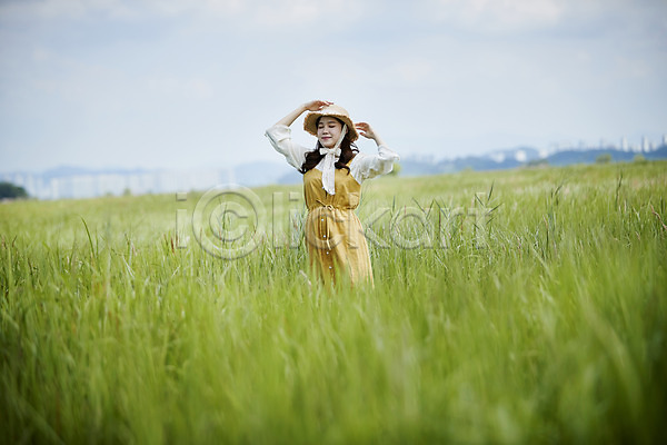 20대 사람 성인여자한명만 여자 한국인 한명 JPG 앞모습 포토 갈대습지 눈감음 만지기 미소(표정) 상반신 서기 손들기 손짓 야외 여름(계절) 우음도 주간 챙모자 하늘