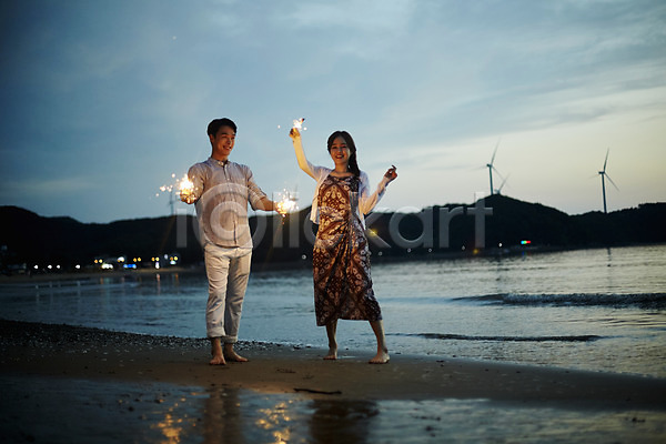 로맨틱 즐거움 20대 남자 두명 사람 성인만 여자 한국인 JPG 앞모습 포토 맨발 모래사장 물결 미소(표정) 불꽃놀이 서기 손들기 야간 야외 여름(계절) 영흥도 전신 조약돌 커플 파도 풍력에너지 해변