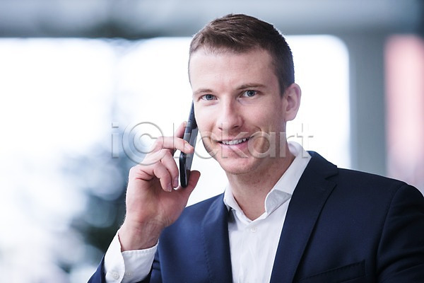 30대 남자 사람 서양인 성인 성인남자한명만 한명 JPG 앞모습 포토 미소(표정) 비즈니스 빌딩 사무실 상반신 스마트폰 실내 응시 창문 통화