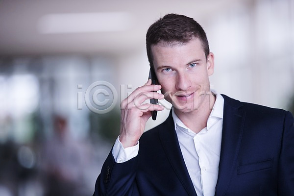 30대 남자 사람 서양인 성인 성인남자한명만 한명 JPG 앞모습 포토 미소(표정) 비즈니스 빌딩 사무실 상반신 서기 스마트폰 실내 응시 통화