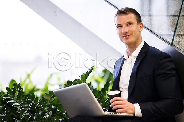 30대 남자 사람 서양인 성인 성인남자한명만 한명 JPG 앞모습 포토 계단 노트북 미소(표정) 비즈니스 사무실 상반신 실내 앉기 정장 직장 커피