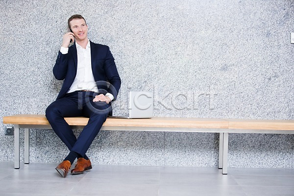 30대 남자 사람 서양인 성인 성인남자한명만 한명 JPG 앞모습 포토 노트북 미소(표정) 비즈니스 비즈니스맨 사무실 실내 앉기 의자 전신 정장 통화 핸드폰
