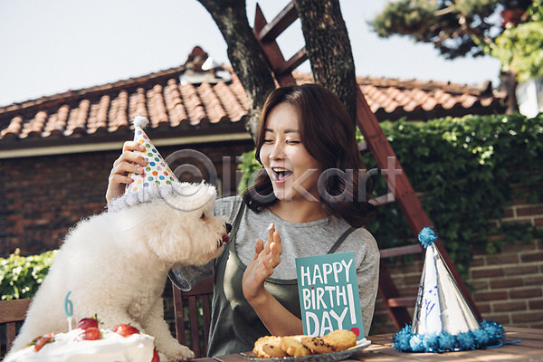 즐거움 20대 사람 성인 성인여자한명만 여자 한국인 한명 JPG 앞모습 포토 강아지 미소(표정) 반려 반려동물 비숑프리제 상반신 생일케이크 생일파티 손짓 야외 주간 쿠키 펫팸족 한마리