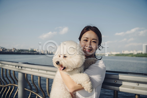 20대 사람 성인 성인여자한명만 여자 한국인 한명 JPG 앞모습 포토 강 강아지 구름(자연) 난간 다리 미소(표정) 반려 반려동물 비숑프리제 상반신 안기 야외 운동 주간 펫팸족 하늘 한마리