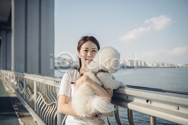 20대 사람 성인 성인여자한명만 여자 한국인 한명 JPG 앞모습 포토 강 강아지 구름(자연) 난간 다리 미소(표정) 반려 반려동물 비숑프리제 상반신 안기 야외 조깅 주간 펫팸족 하늘 한마리