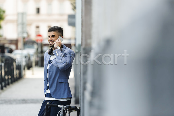 20대 남자 사람 서양인 성인 성인남자한명만 한명 JPG 옆모습 포토 미소(표정) 보행로 상반신 야외 자전거 주간 통화 프라하 핸드폰 헤드셋