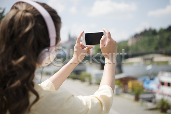 20대 사람 서양인 성인 성인여자한명만 여자 한명 JPG 뒷모습 포토 들기 사진촬영 상반신 성 야외 여행 주간 풍경(경치) 프라하 핸드폰 헤드셋