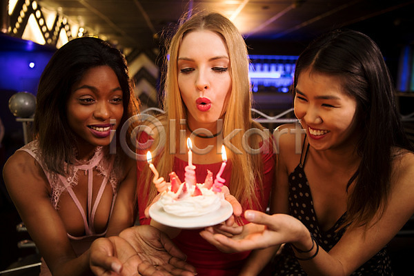 즐거움 축하 20대 30대 동양인 사람 서양인 성인 성인여자만 세명 여자 흑인 JPG 앞모습 포토 들기 미소(표정) 바람불기 상반신 생일 생일축하 실내 조명 촛불 친구 케이크 클럽 파티