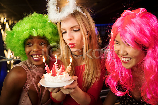 즐거움 축하 20대 30대 동양인 사람 서양인 성인 성인여자만 세명 여자 흑인 JPG 앞모습 포토 가발 머리띠 미소(표정) 분장 불기 상반신 생일 생일축하 실내 응시 촛불 친구 케이크 클럽 파티
