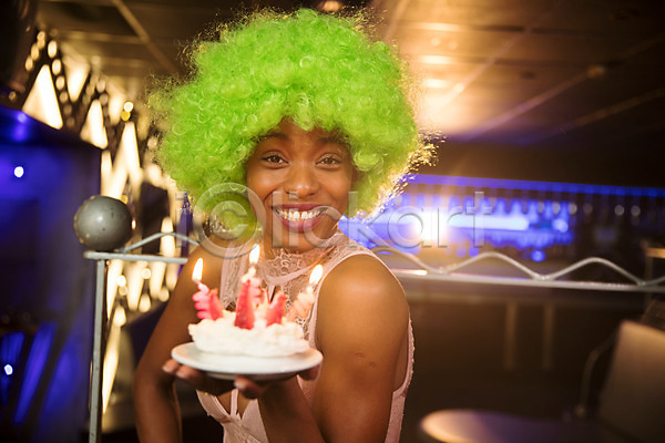 즐거움 축하 30대 사람 성인 성인여자한명만 여자 한명 흑인 JPG 옆모습 포토 가발 들기 미소(표정) 상반신 생일 생일축하 소파 실내 응시 조명 촛불 케이크 클럽 파티