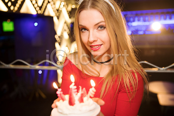 축하 20대 사람 서양인 성인 성인여자한명만 여자 한명 JPG 앞모습 포토 들기 미소(표정) 상반신 생일 생일축하 실내 응시 조명 촛불 케이크 클럽 파티