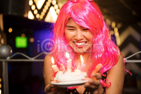 즐거움 축하 20대 동양인 사람 성인 성인여자한명만 신체부위 여자 한명 JPG 앞모습 포토 가발 들기 미소(표정) 상반신 생일 생일축하 실내 얼굴 응시 조명 촛불 케이크 클럽 파티
