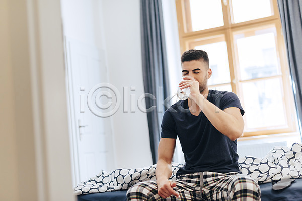 20대 남자 사람 서양인 성인 성인남자한명만 한명 JPG 앞모습 포토 마시기 물 상반신 실내 앉기 이불 창문 침대 침실 한잔