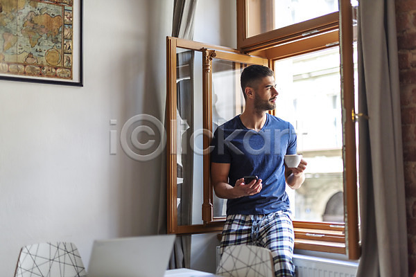 20대 남자 사람 서양인 성인 성인남자한명만 한명 JPG 앞모습 포토 노트북 들기 상반신 실내 앉기 응시 의자 창가 창문 창밖 커피잔 탁자 핸드폰