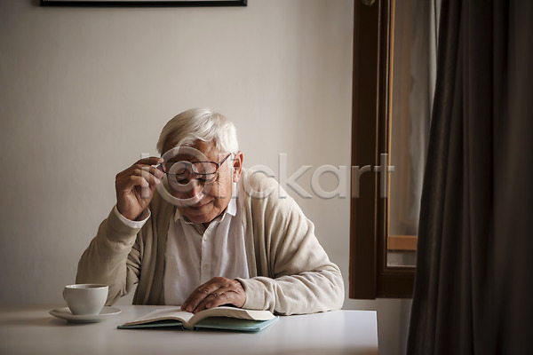 70대 남자 노년 노인남자한명만 사람 서양인 한명 JPG 앞모습 포토 독서 벗기 상반신 실내 실버라이프 안경 잡기 주간 창가 책 커튼 커피잔 탁자